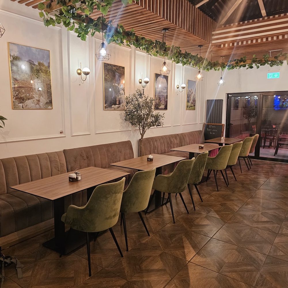Green velvet chairs, banquette seating and parquet floor in the dining room